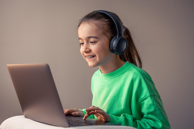 A menina com portátil joga o conceito dos jogos do vício do jogo