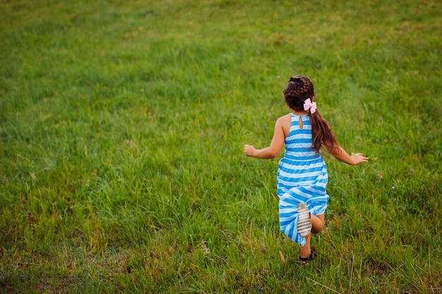 Foto grátis a menina corre no campo verde