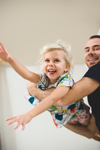 Foto grátis a menina de sorriso nos braços de seu pai