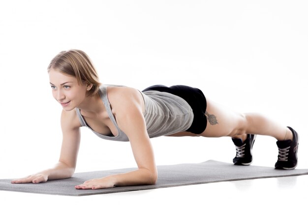 A menina no sportswear fazendo exercícios de resistência