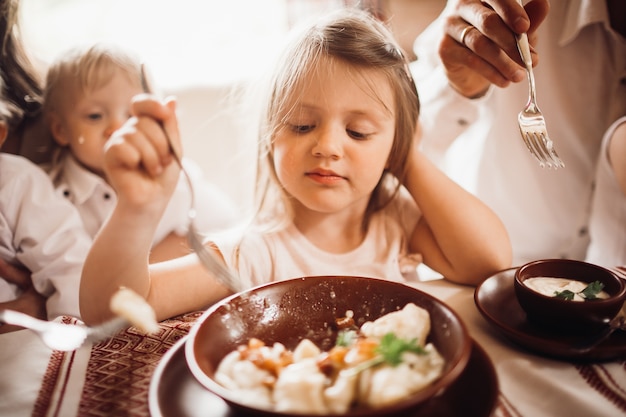 A menina parece pensativa comendo os bolinhos