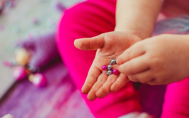 A menina pequena brincando com bolas e pedras