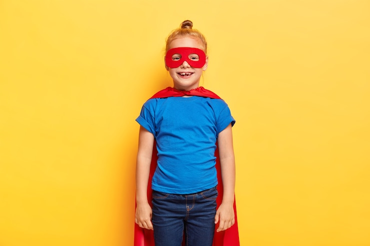 Foto grátis a menina super-heroína usa um terno especial com capa vermelha