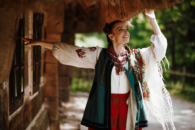 A moça em um vestido ucraniano colorido dança e sorri