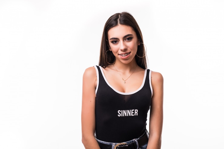 Foto grátis a morena de sorriso da mulher fica na frente do branco