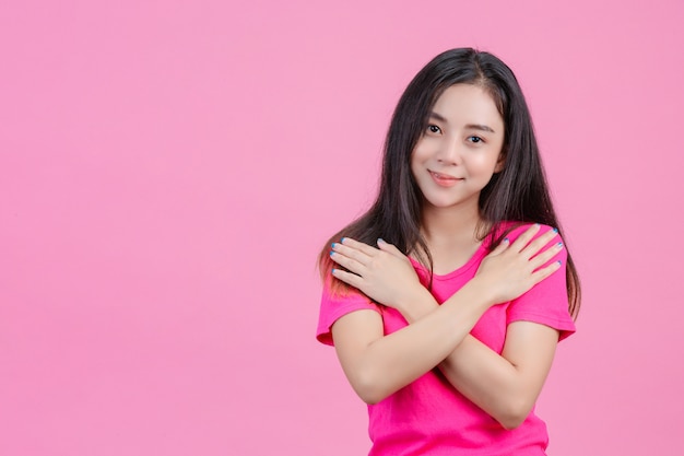 A mulher asiática branca bonito levanta e ama-se em um rosa.