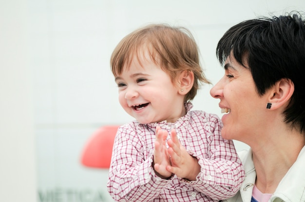 A mulher bonita e sua filha pequena estão abraçando