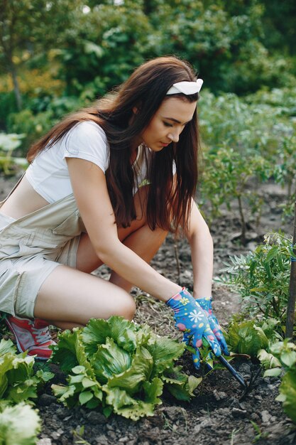 A mulher bonita trabalha em um jardim