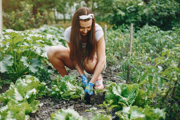 A mulher bonita trabalha em um jardim