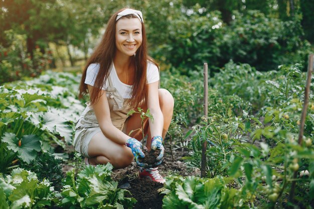 A mulher bonita trabalha em um jardim