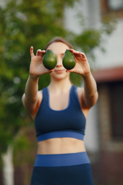 A mulher em um sportwear prende frutas