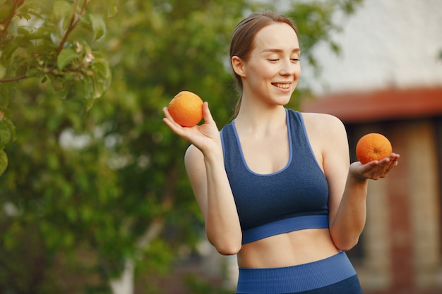 A mulher em um sportwear prende frutas