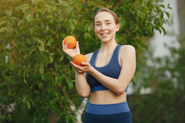A mulher em um sportwear prende frutas