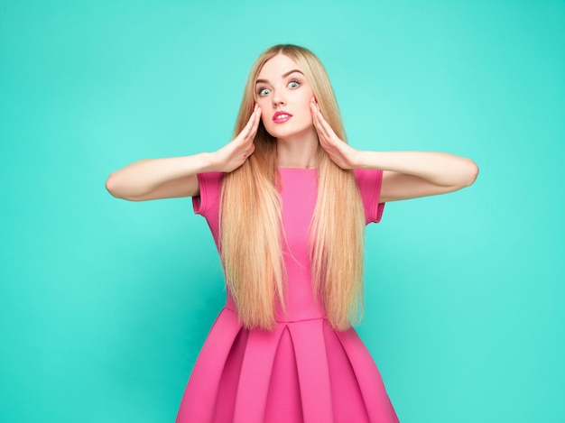 Foto grátis a mulher jovem e bonita no vestido rosa mini posando no estúdio