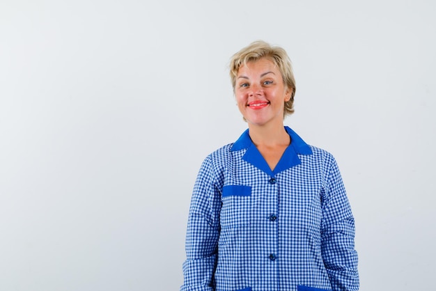 A mulher loira está sorrindo para a câmera no fundo branco