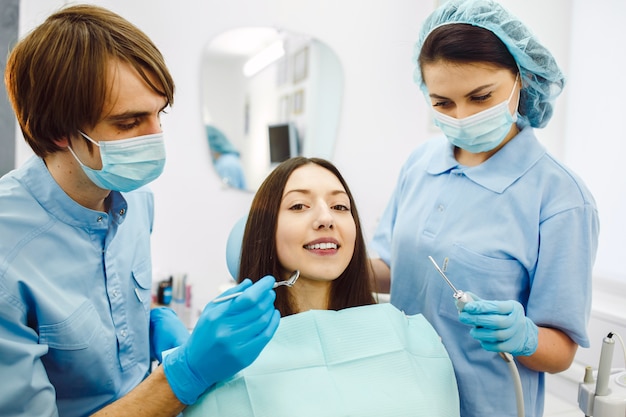 A mulher na recepção no dentista com assistente