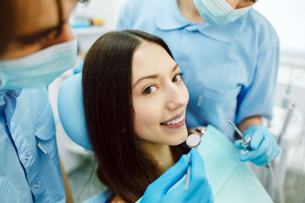 A mulher na recepção no dentista com assistente