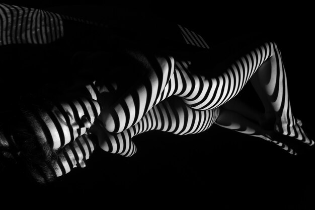 A mulher nua com listras de zebra preto e branco