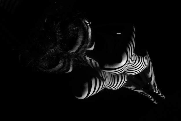 A mulher nua com listras de zebra preto e branco