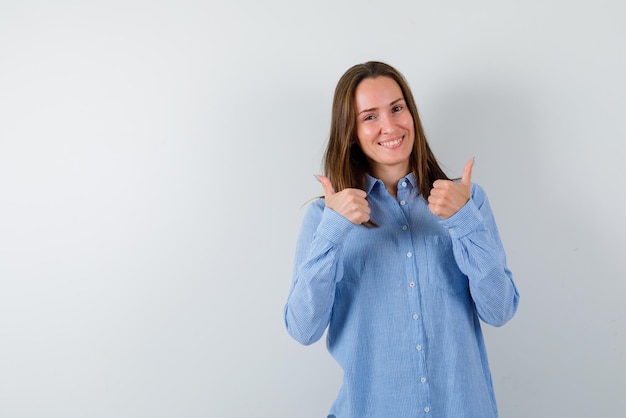 A mulher sorridente está mostrando os polegares no fundo branco