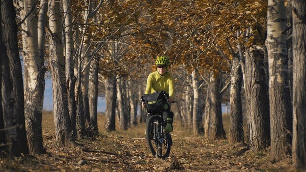 A mulher viaja em cicloturismo de terreno misto com bikepacking. a viagem do viajante com malas de bicicleta. bikepacking de turismo esportivo.