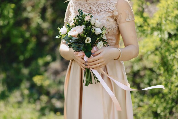 A noiva tem um buquê de casamento nas mãos dela