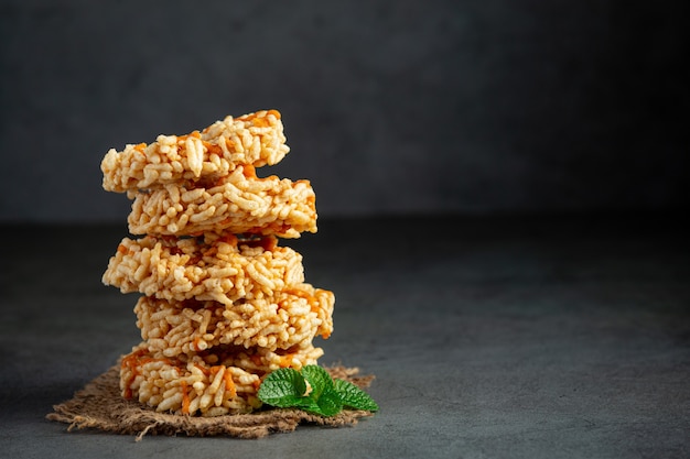 A pilha de lanche tailandês kao tan ou biscoito de arroz no chão escuro