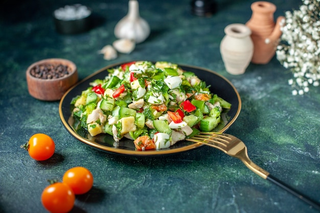 A salada de legumes com vista frontal consiste em queijo de pepino e tomates em fundo azul escuro