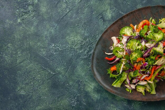 A salada de vegetais da vista de cima consiste em pimentas, repolho e brócolis em fundo escuro comida refeição fresca saúde dieta lanche maduro vitamina espaço livre