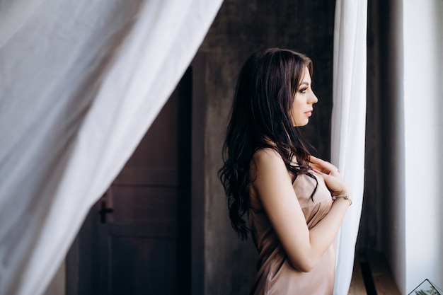 Foto grátis a senhora da elegância fica perto da janela