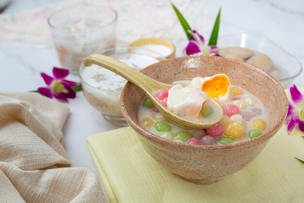 A sobremesa tailandesa chamou bolas de Bualoy em colheres com leite de coco quente e folhas de pandan para aumentar a delícia.