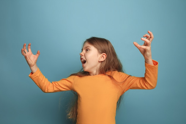 A surpresa. Menina adolescente em um azul. Expressões faciais e conceito de emoções de pessoas