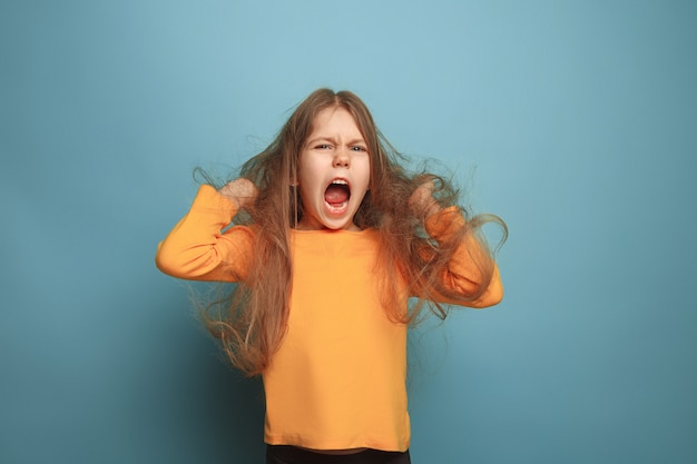 Foto grátis a surpresa. menina adolescente em um azul. expressões faciais e conceito de emoções de pessoas