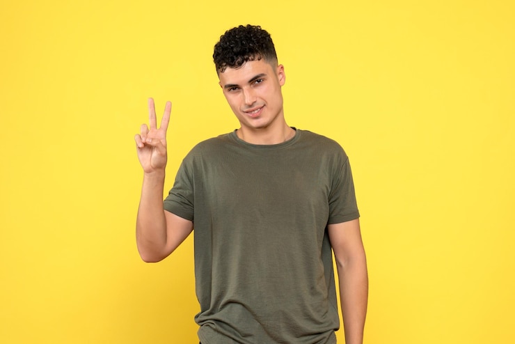 Foto grátis a visão frontal do cara sorridente olha para frente e mostra os dedos em sua mão