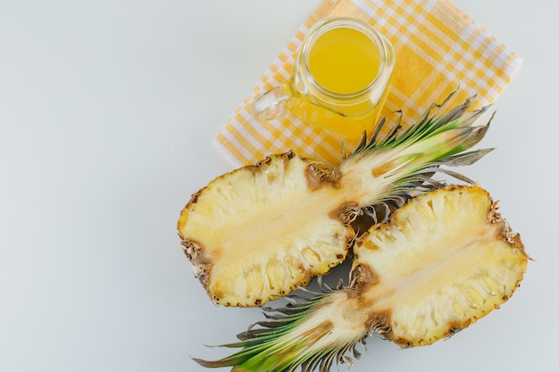 Abacaxi com suco na superfície de toalha branca e cozinha