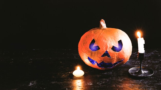 Abóbora decorativa de Halloween com rosto esculpido iluminado dentro com velas em chamas