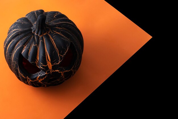 Abóbora preta de Halloween em fundo preto e laranja