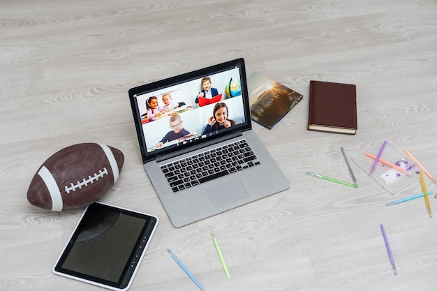 Abra o laptop com bola de futebol ou rúgbi no chão, bate-papo por vídeo