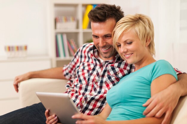 Abraçando casal usando tablet digital