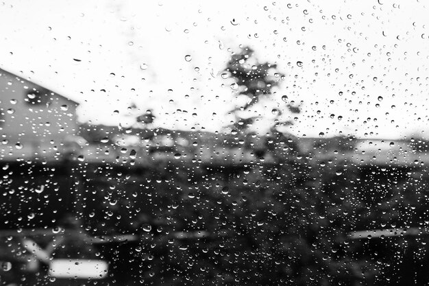 Abstrato com pingos de chuva na foto preto e branco de vidro