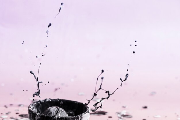 Abstrato com respingo de tinta escura e copo