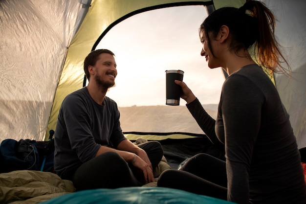 Acampamento de casal aventureiro de tiro completo