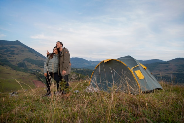 Foto grátis acampamento de casal aventureiro de tiro completo