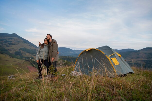 Acampamento de casal aventureiro de tiro completo