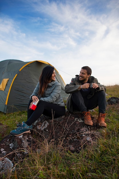 Acampamento de casal aventureiro de tiro completo