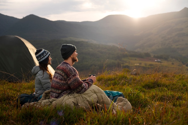 Acampamento de casal aventureiro de tiro completo