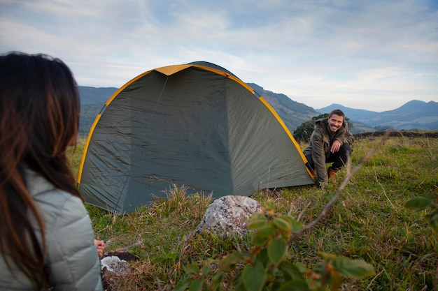 Acampamento de casal aventureiro de vista lateral