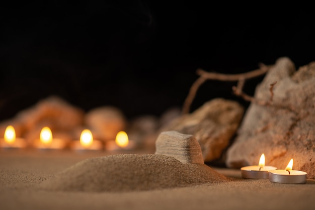 Acendendo velas com pedras ao redor da pequena sepultura como memória funeral de morte