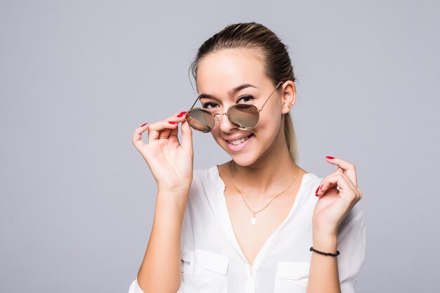 Acessórios, óculos, moda, pessoas e conceito de luxo - bela jovem em elegantes óculos de sol pretos sobre a parede cinza