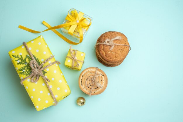 Acima, vista de várias caixas de presente amarelas de biscoitos deliciosos empilhados em fundo verde pastel